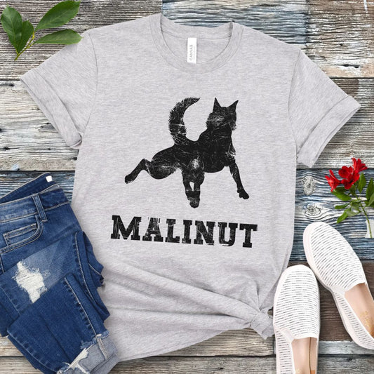 Light grey t-shirt with leaping Belgian Malinois silhouette and 'MALINUT' text on a wooden surface with jeans and shoes.