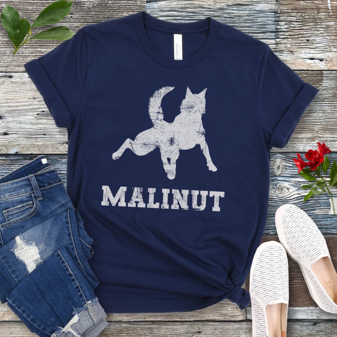 Navy blue t-shirt with leaping Belgian Malinois silhouette and 'MALINUT' text on a wooden surface with jeans and shoes.