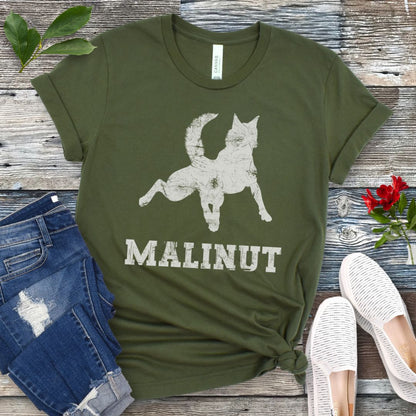 Military green t-shirt with leaping Belgian Malinois silhouette and 'MALINUT' text on a wooden surface with jeans and shoes.