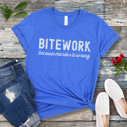 Royal blue Schutzhund t-shirt with 'BITEWORK because murder is wrong' text on a wooden surface with jeans and shoes.