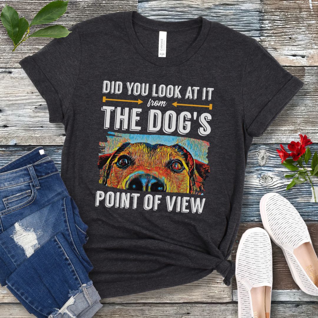 Dark grey dog training t-shirt with colorful dog face graphic and the text 'Did You Look At It From Your Dog's Point of View', laid flat with jeans and white shoes.