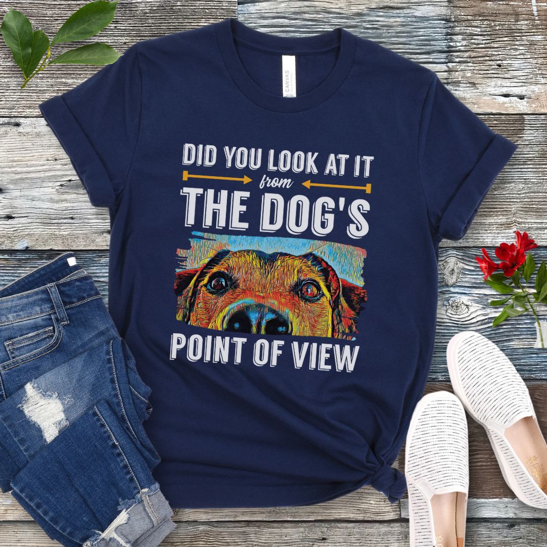 Navy blue dog trainer t-shirt with colorful dog face graphic and the text 'Did You Look At It From Your Dog's Point of View', laid flat with jeans and white shoes.