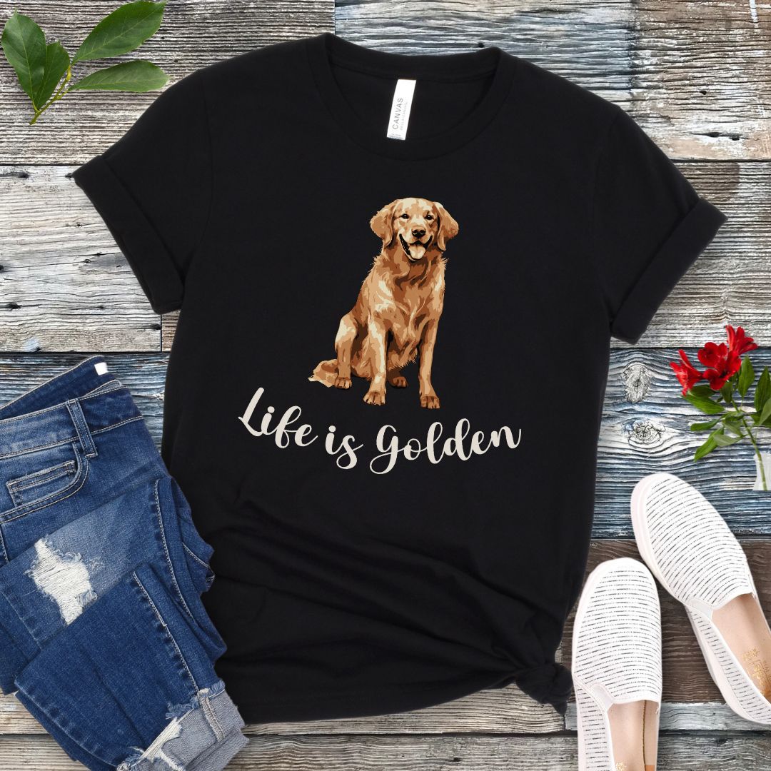 Black t-shirt with a Golden Retriever illustration and 'Life is Golden' text on a wooden surface with jeans and shoes.