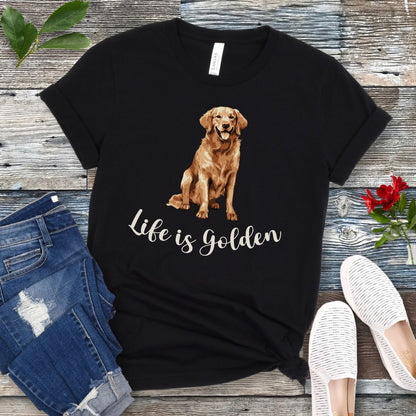 Black t-shirt with a Golden Retriever illustration and 'Life is Golden' text on a wooden surface with jeans and shoes.