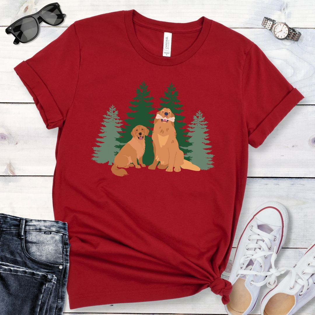 Dark red dog lover t-shirt with graphic of 2 Golden Retrievers in front of an evergreen forest, shown on a wooden surface with jeans and shoes.