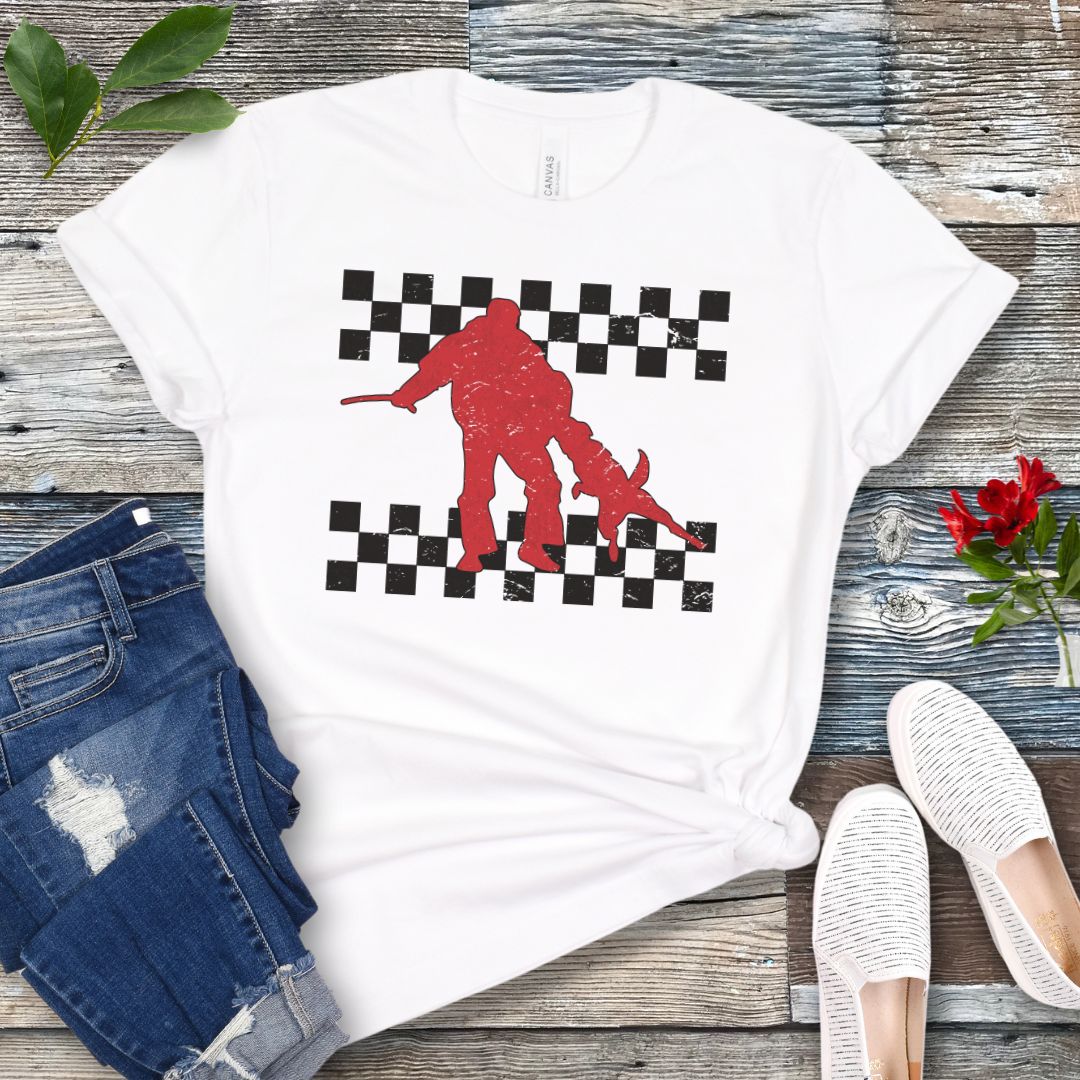 Dark grey Schutzhund t-shirt with bite work dog and checkerboard design, presented on a wooden surface with jeans and shoes.