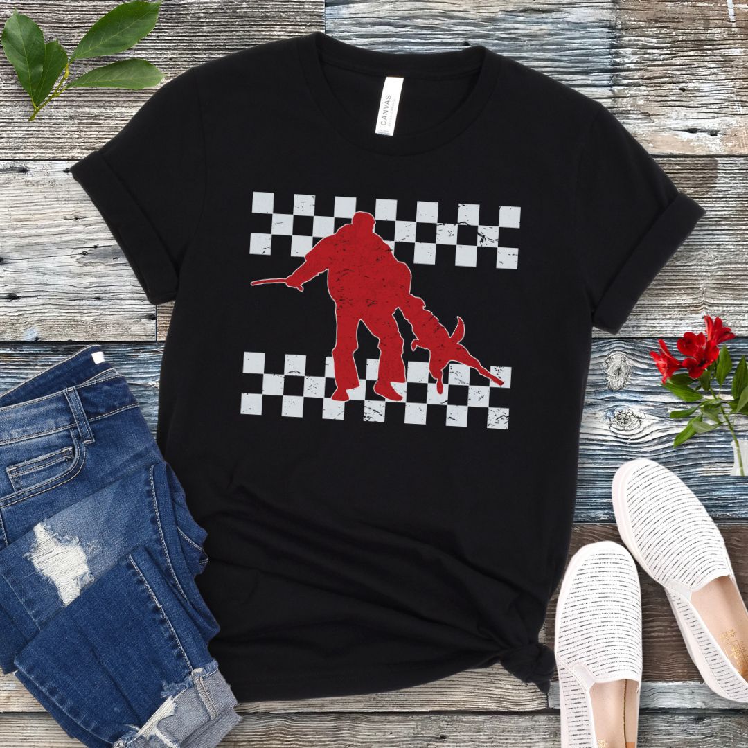 Black bite work t-shirt with protection dog, K9 helper, and checkerboard design, presented on a wooden surface with jeans and shoes.