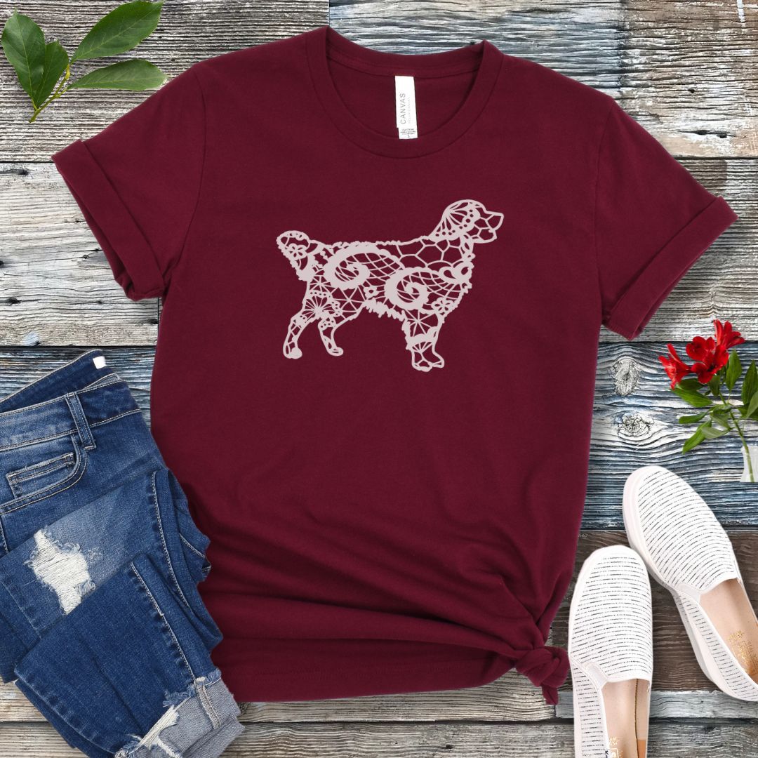Maroon t-shirt for Golden dog moms with faux-lace design of a Golden Retriever, shown on a wooden surface with jeans and shoes.