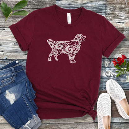 Maroon t-shirt for Golden dog moms with faux-lace design of a Golden Retriever, shown on a wooden surface with jeans and shoes.
