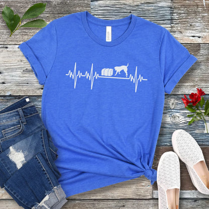 Blue dog sports t-shirt with heartbeat/EKG and barn hunt dog design on a wooden surface with jeans and shoes.