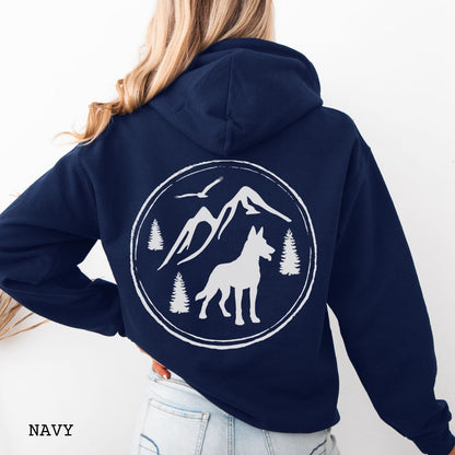 Navy blue Belgian Malinois hoodie featuring a bold vintage-style back print with Malinois silhouette, mountains, pine trees, perfect gift for hiking and outdoorsy Belgian Shepherd dog lovers.