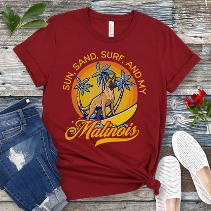 Dark red unisex retro tropical Belgian Malinois beach t-shirt featuring a surfing Malinois with palm trees and sunset design, perfect for Malinois owners, working dog lovers, beach dog moms, and summer adventure fans.