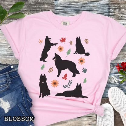 Pink cottagecore style dog lover t-shirt with Belgian Sheepdog silhouettes and colorful leaves on a wooden surface.
