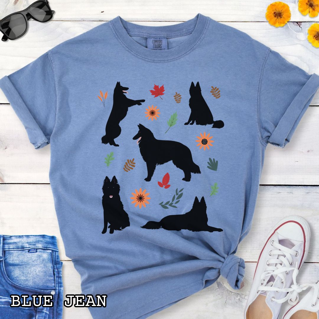 Blue cottagecore style dog lover t-shirt with Belgian Sheepdog silhouettes and colorful leaves on a wooden surface.