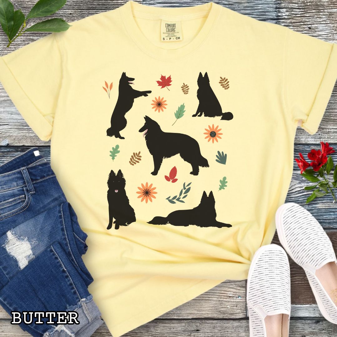 Yellow cottagecore style dog lover t-shirt with Belgian Sheepdog silhouettes and colorful leaves on a wooden surface.