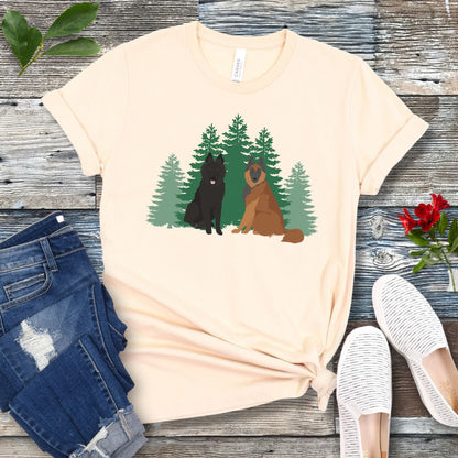 Beige Belgian Shepherd t-shirt with Belgian Sheepdog and Tervuren sitting in front of evergreen trees, shown on a wooden surface with jeans and shoes.