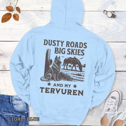 Back view of light blue hoodie featuring a Western-style design with grazing horse, rustic fence, and a Belgian Tervuren illustration; text reads “Dusty Roads, Big Skies, and My Tervuren.”
