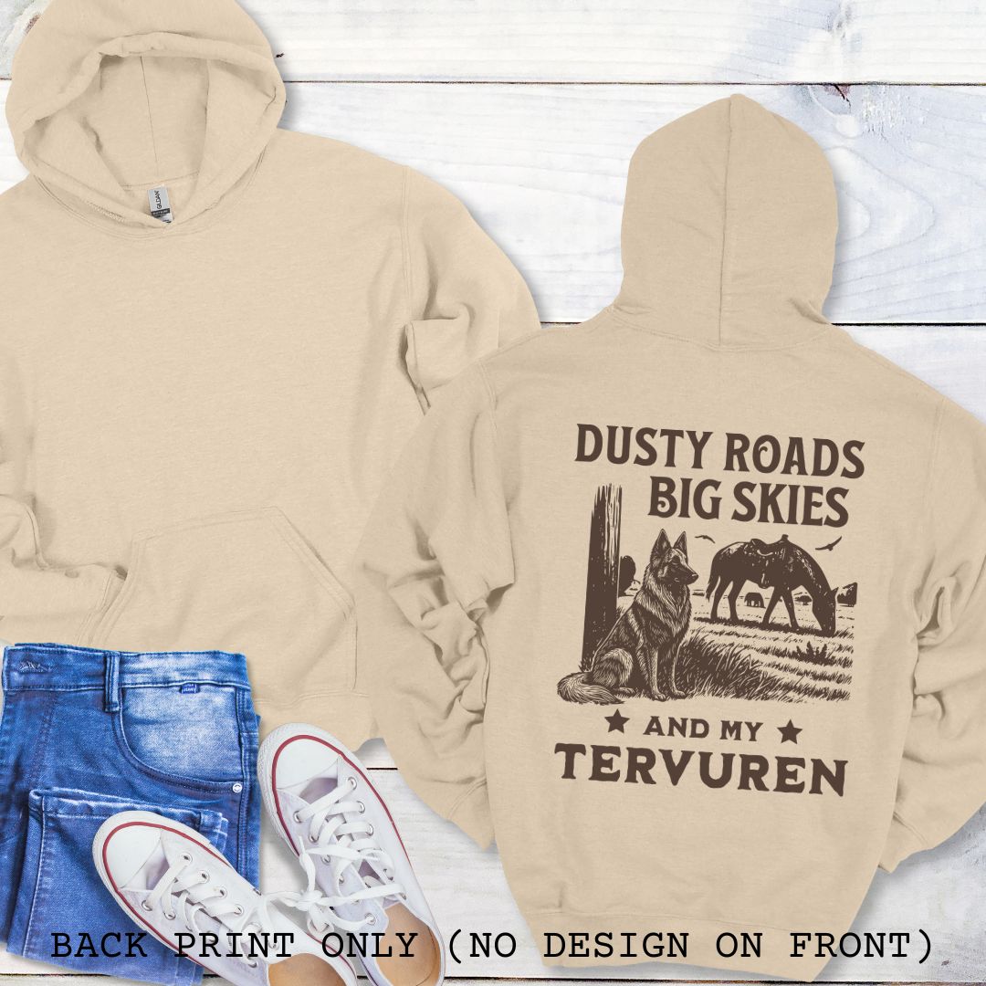 Beige hoodie with 'Dusty Roads Big Skies And My Tervuren' text and wolf design, paired with jeans and sneakers on a light wooden surface.