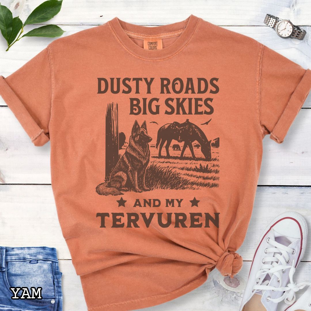 Yam-orange Comfort Colors t-shirt featuring a Western-style design with grazing horse, rustic fence, and a Belgian Tervuren illustration; text reads “Dusty Roads, Big Skies, and My Tervuren.”