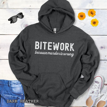 Dark Grey Schutzhund/IGP hoodie with 'BITEWORK because murder is wrong' text on a wooden surface with jeans and shoes.