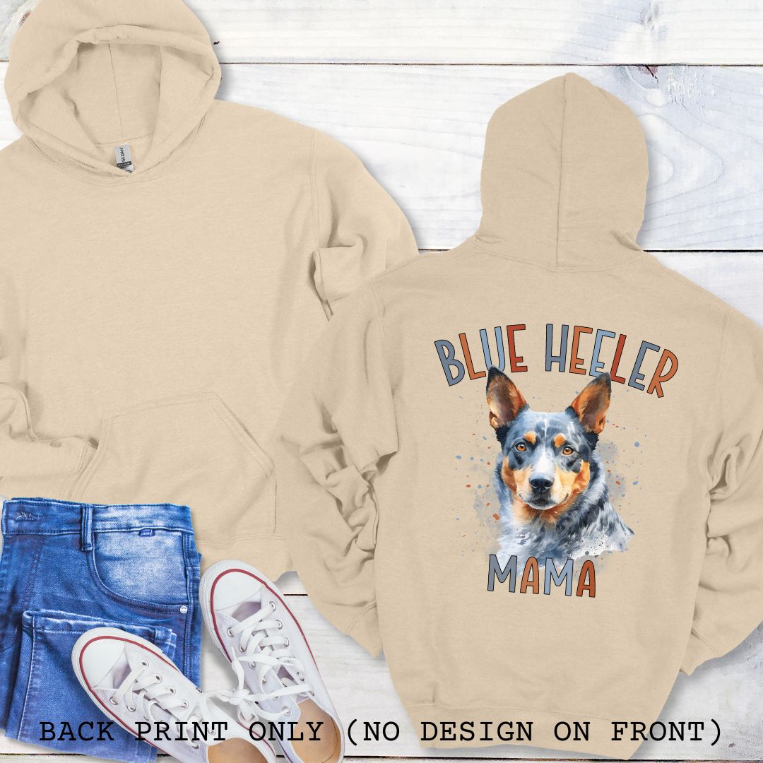 Beige Australian Cattle Dog hoodie with blue heeler graphic and 'Blue Heeler Mama' multicolor text on the back, on a wood background
