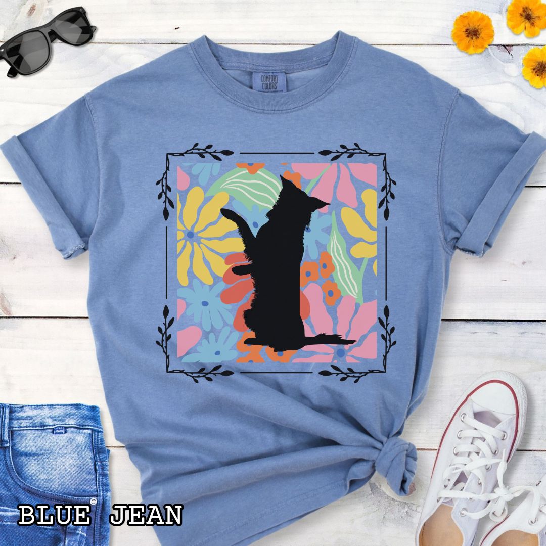 Blue Comfort Colors t-shirt with a Border Collie silhouette framed by colorful, Boho-style flowers and foliage. Displayed with jeans and a flower.