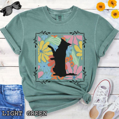 Green Comfort Colors t-shirt with a Border Collie silhouette framed by colorful, Boho-style flowers and foliage. Displayed with jeans and a flower.