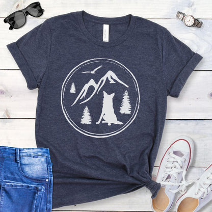 Navy t-shirt for outdoorsy dog lovers, with a minimalist mountain scene and Border Collie, shown on a wooden surface with jeans and sneakers.