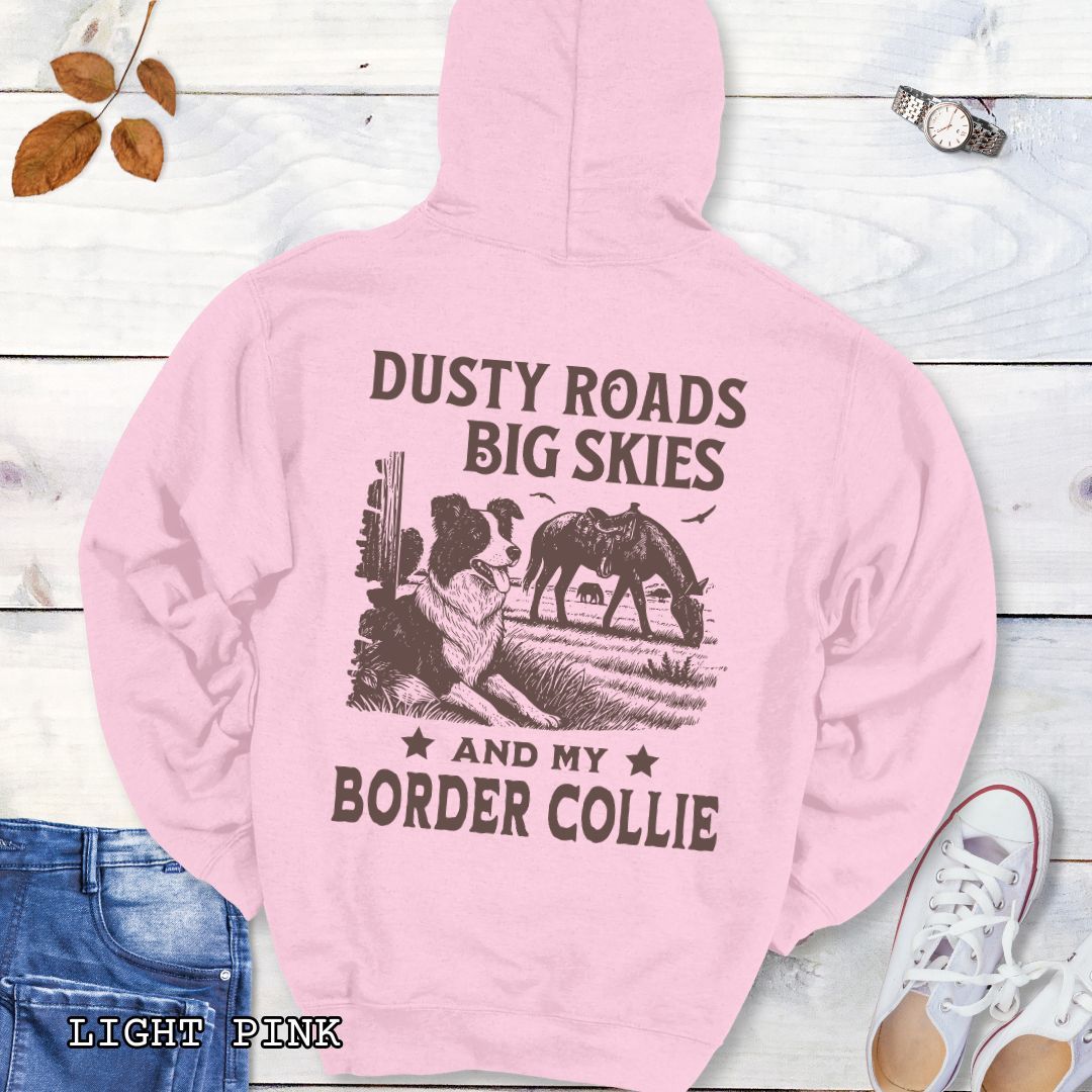 Back view of light pink Border Collie hoodie featuring a Western-style design with grazing horse, rustic fence, and an Border Collie illustration; text reads “Dusty Roads, Big Skies, and My Border Collie.”
