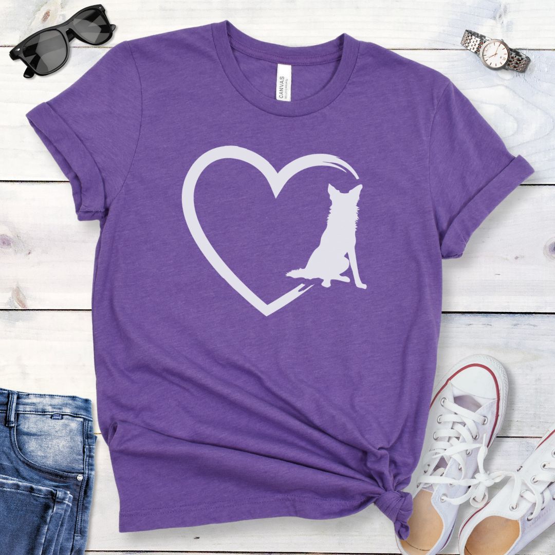 Purple t-shirt for Border Collie lovers with a sketched heart intersected by a sitting Border Collie dog, shown on a wooden surface with jeans and shoes.