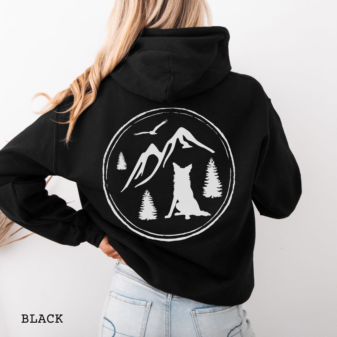 Person wearing a Black Border Collie back print hoodie featuring a vintage-style mountain, pine tree, and Border Collie silhouette back print for hiking enthusiasts, outdoor dog lovers, and Border Collie owners.
