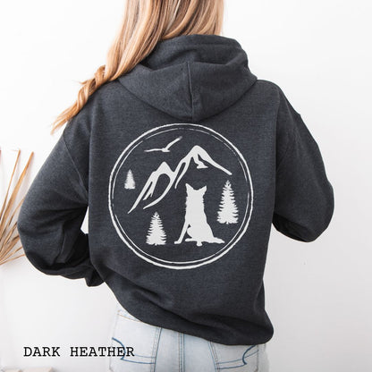 Person wearing a dark grey Border Collie back print hoodie featuring a vintage-style mountain, pine tree, and Border Collie silhouette back print for hiking enthusiasts, outdoor dog lovers, and Border Collie owners.