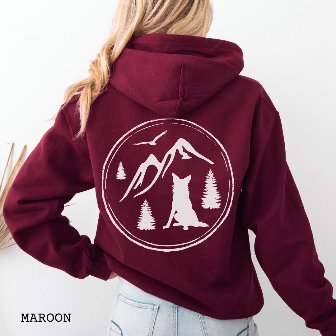 Person wearing a Maroon Border Collie back print hoodie featuring a vintage-style mountain, pine tree, and Border Collie silhouette back print for hiking enthusiasts, outdoor dog lovers, and Border Collie owners.