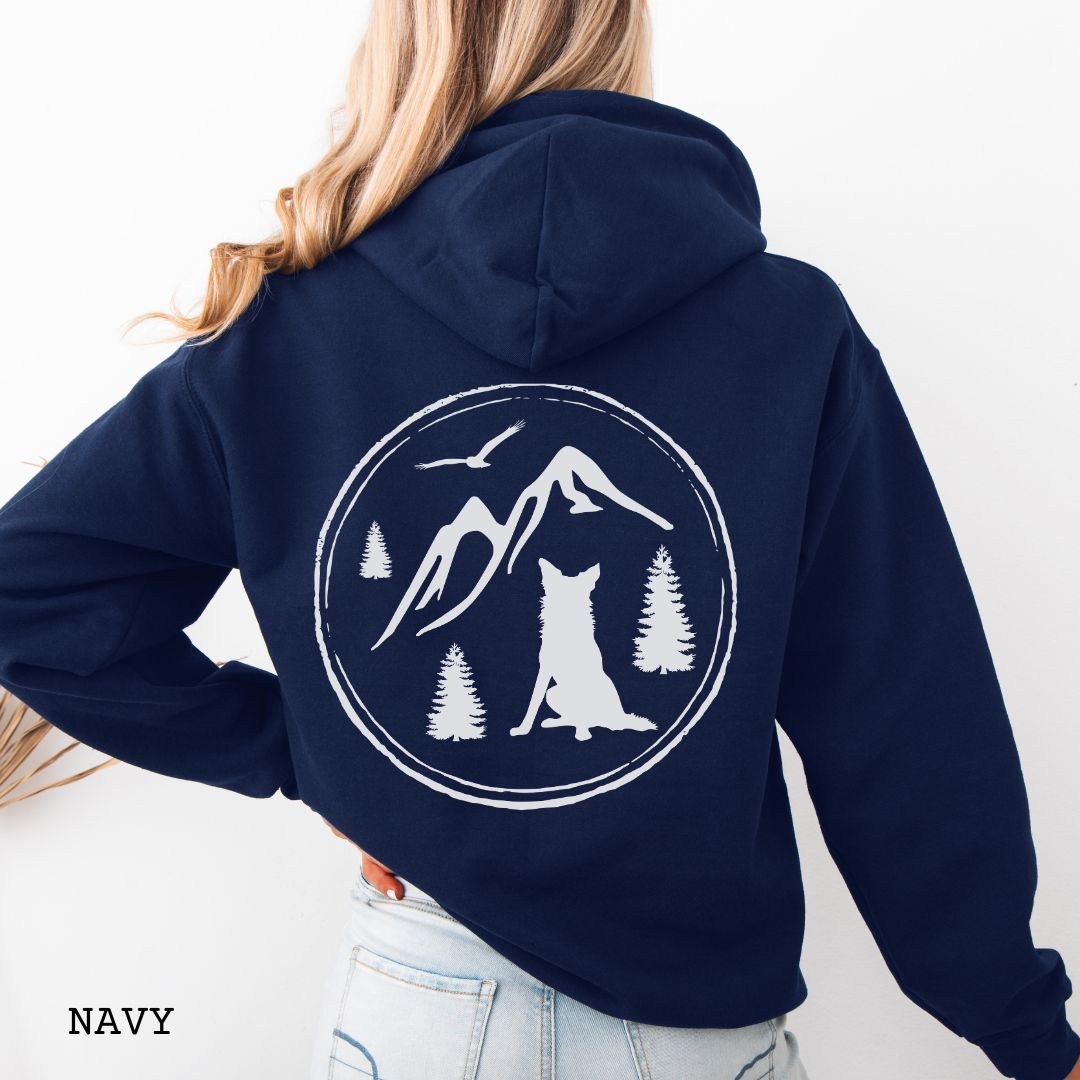 Person wearing a Navy blue Border Collie back print hoodie featuring a vintage-style mountain, pine tree, and Border Collie silhouette back print for hiking enthusiasts, outdoor dog lovers, and Border Collie owners.