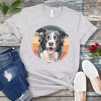 Light grey t-shirt for Border Collie lovers with a Border Collie face in a vintage style retro sunset graphic. Presented on a wooden surface with jeans and sneakers.