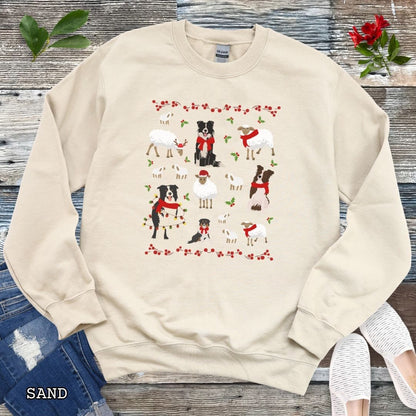 Sand Gildan 18000 Border Collies and Sheep Christmas sweatshirt featuring festive sheep, Border Collies, Santa hats, scarves, and holly for herding dog lovers.