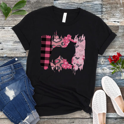 Black Collie lover t-shirt with a black silhouette of a  Rough Collie on a pink and plaid brushstroke background, placed on a wooden surface with jeans and shoes.