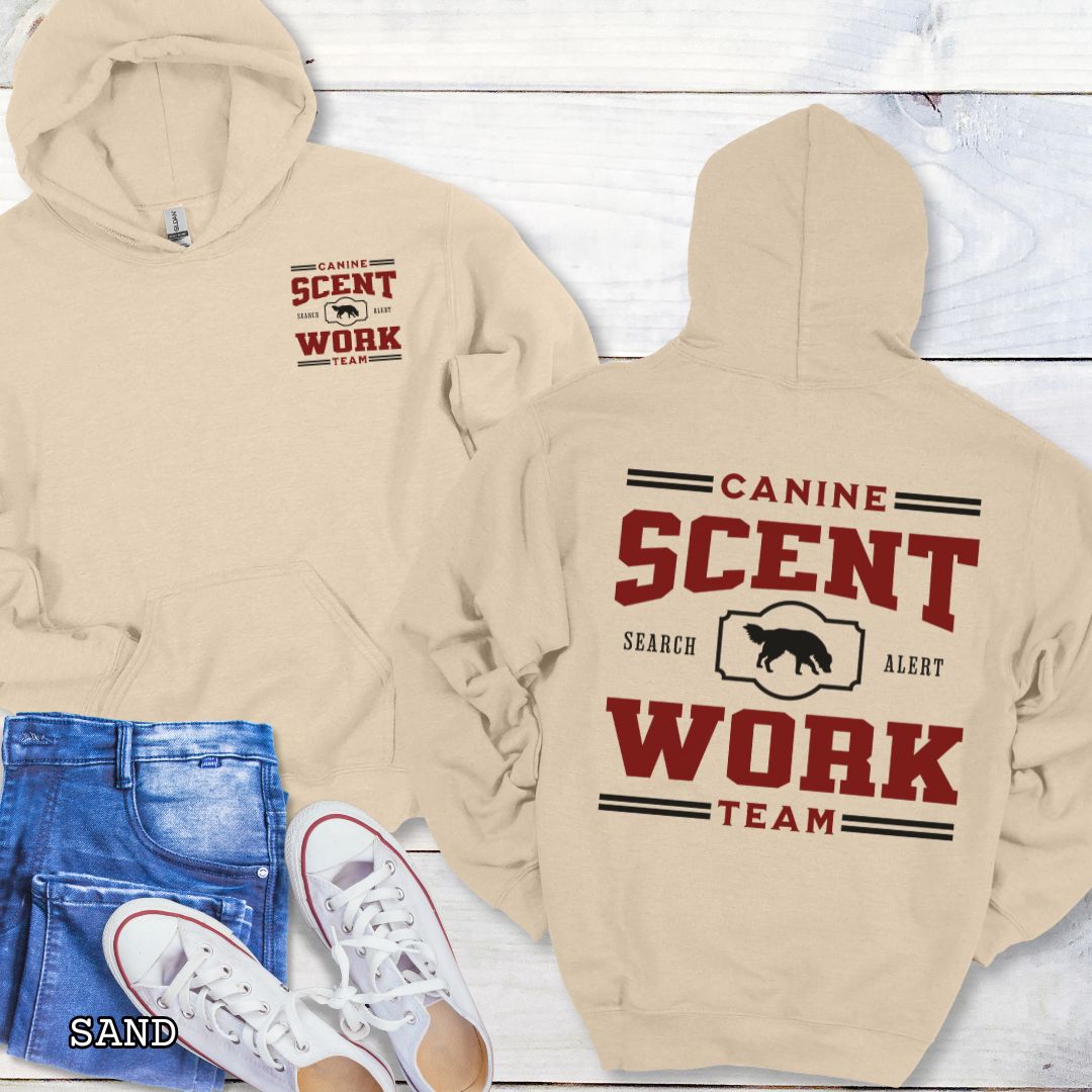 Beige back print hoodie with 'Canine Scent Work Team' text on a wooden surface.