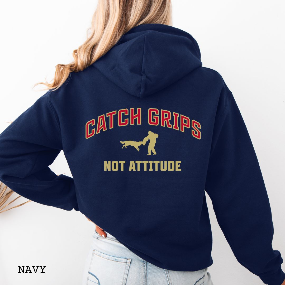Navy blue Schutzhund/IGP hoodie with bitework graphic and 'Catch Grips Not Attitude' text in college style lettering on the back, worn by a person. 