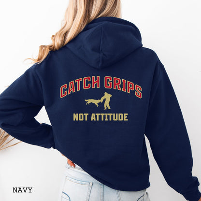 Navy blue Schutzhund/IGP hoodie with bitework graphic and 'Catch Grips Not Attitude' text in college style lettering on the back, worn by a person. 