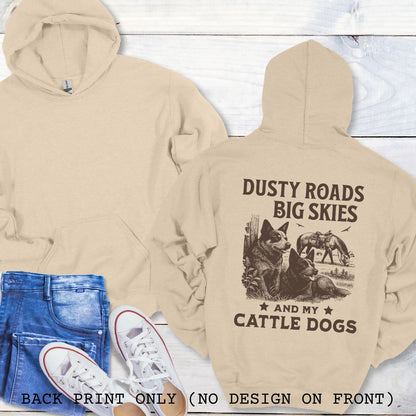 Back view of sand-beige Blue Heeler hoodie featuring a Western-style design with grazing horse, rustic fence, and Cattle Dog illustration; text reads “Dusty Roads, Big Skies, and My Cattle Dogs.”