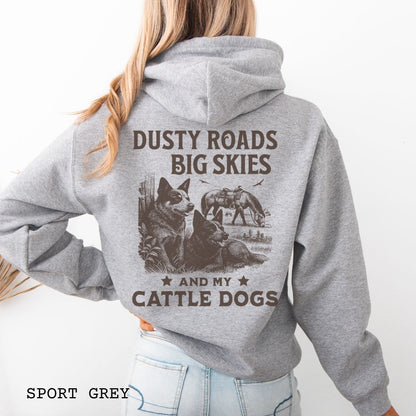 Back view of grey Blue Heeler hoodie featuring a Western-style design with grazing horse, rustic fence, and Cattle Dog illustration; text reads “Dusty Roads, Big Skies, and My Cattle Dogs.”