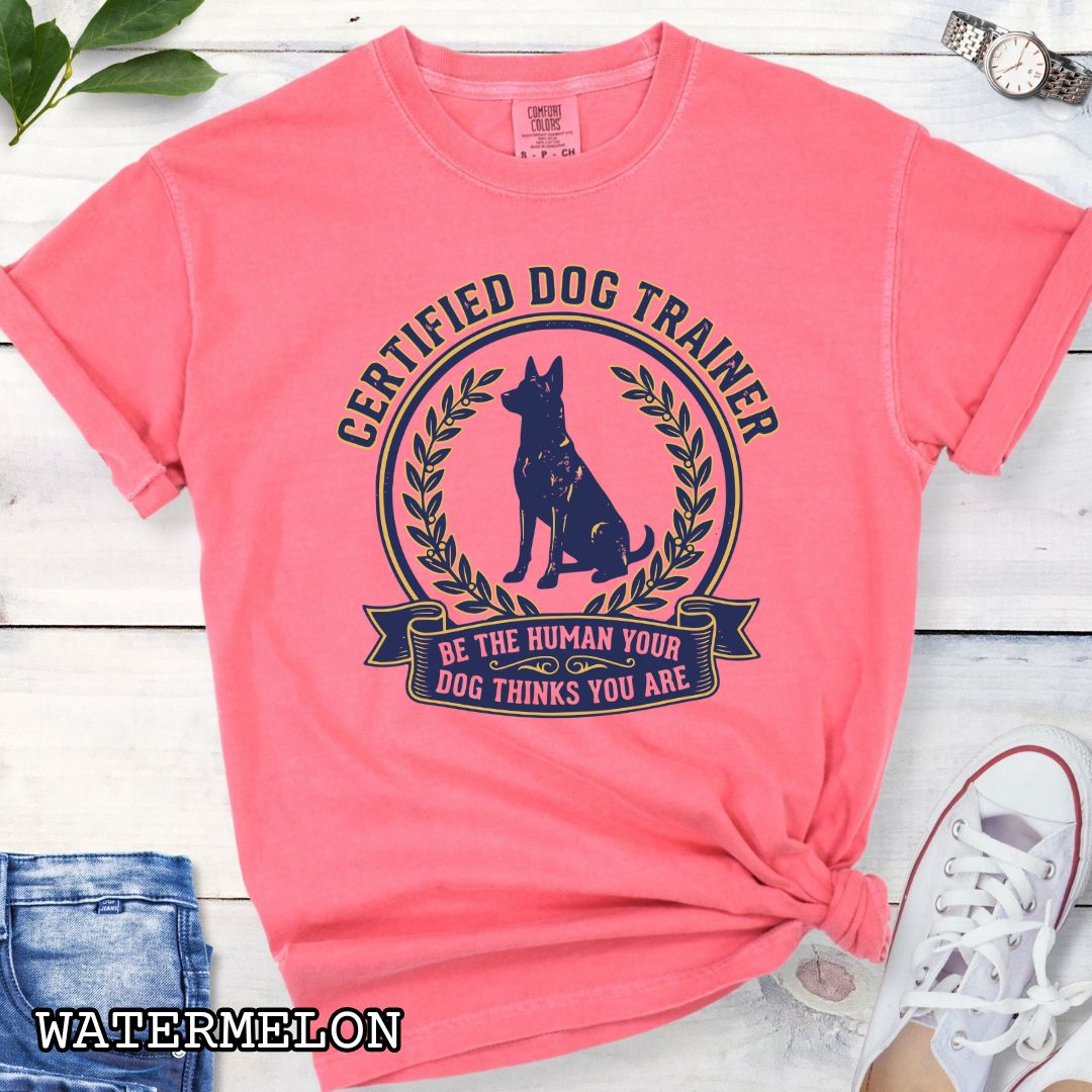 Pink Comfort Colors t-shirt featuring a Certified Dog Trainer design with dog silhouette and Be the Human Your Dog Thinks You Are message, professional dog trainer shirt for canine trainers, obedience instructors, and dog training professionals.