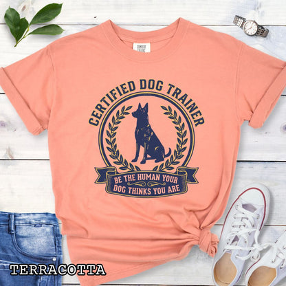 Orange Comfort Colors t-shirt featuring a Certified Dog Trainer design with dog silhouette and Be the Human Your Dog Thinks You Are message, professional dog trainer shirt for canine trainers, obedience instructors, and dog training professionals.