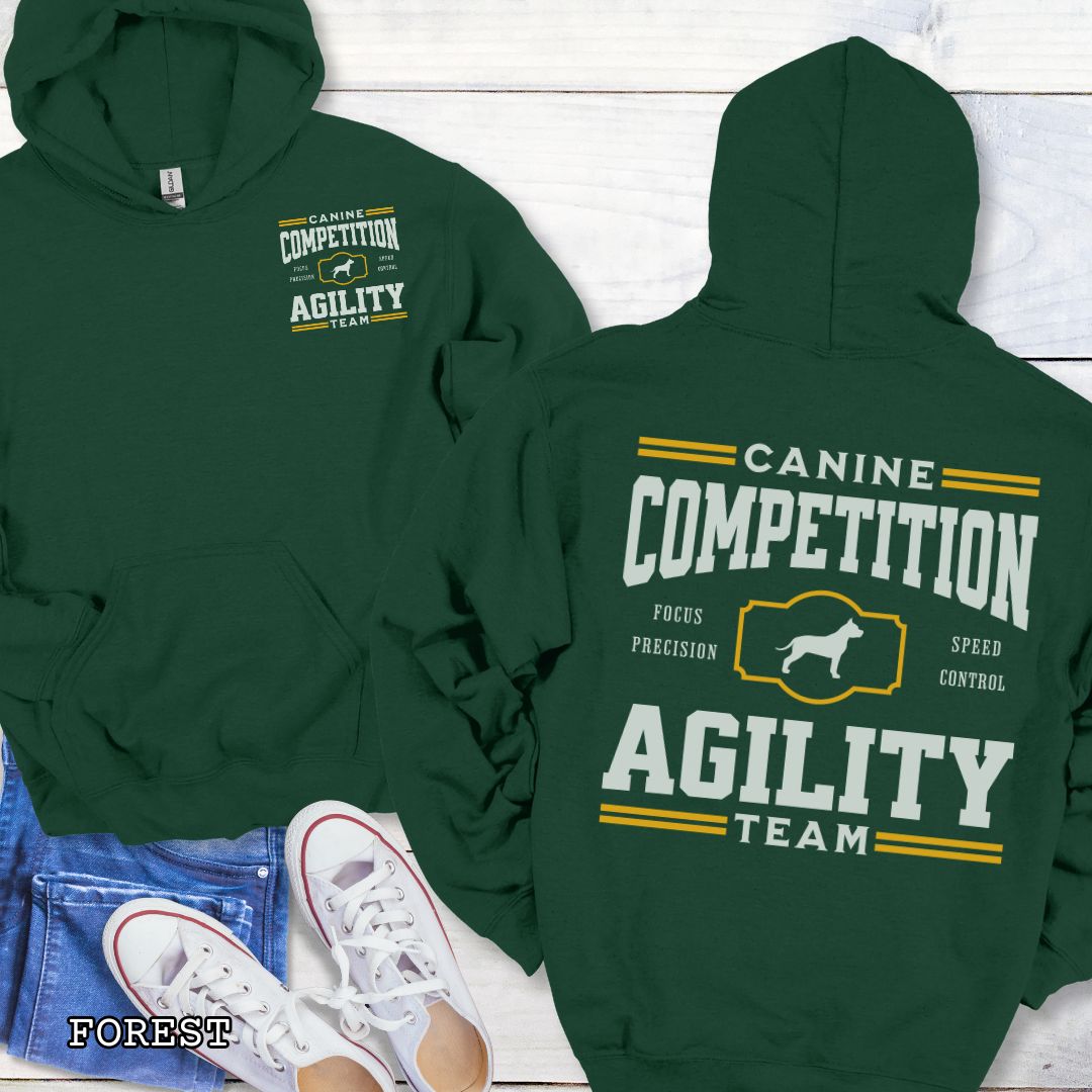 Green dog agility hoodie with 'Canine Competition Agility Team' text and custom breed silhouette, presented graphics on a wooden surface.