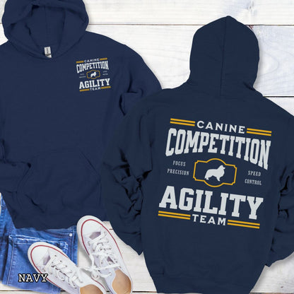 Navy dog agility hoodie with 'Canine Competition Agility Team' text and custom breed silhouette, presented graphics on a wooden surface.