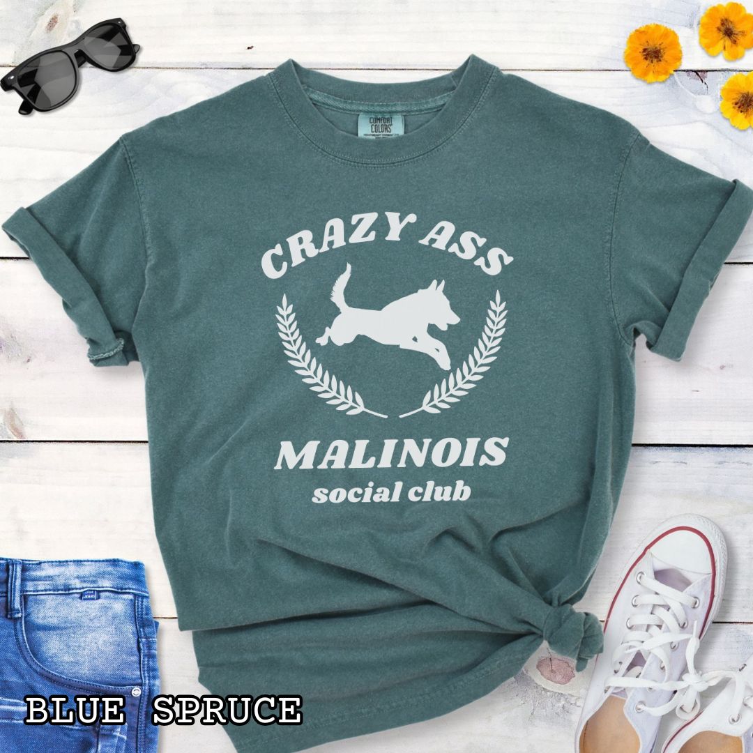 Green Comfort Colors t-shirt with funny Crazy Ass Malinois Social Club design with jumping Belgian Malinois silhouette, perfect gift for Malinois owners, dog trainers, K9 handlers, working dog fans, and protection sport enthusiasts.