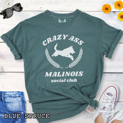 Green Comfort Colors t-shirt with funny Crazy Ass Malinois Social Club design with jumping Belgian Malinois silhouette, perfect gift for Malinois owners, dog trainers, K9 handlers, working dog fans, and protection sport enthusiasts.