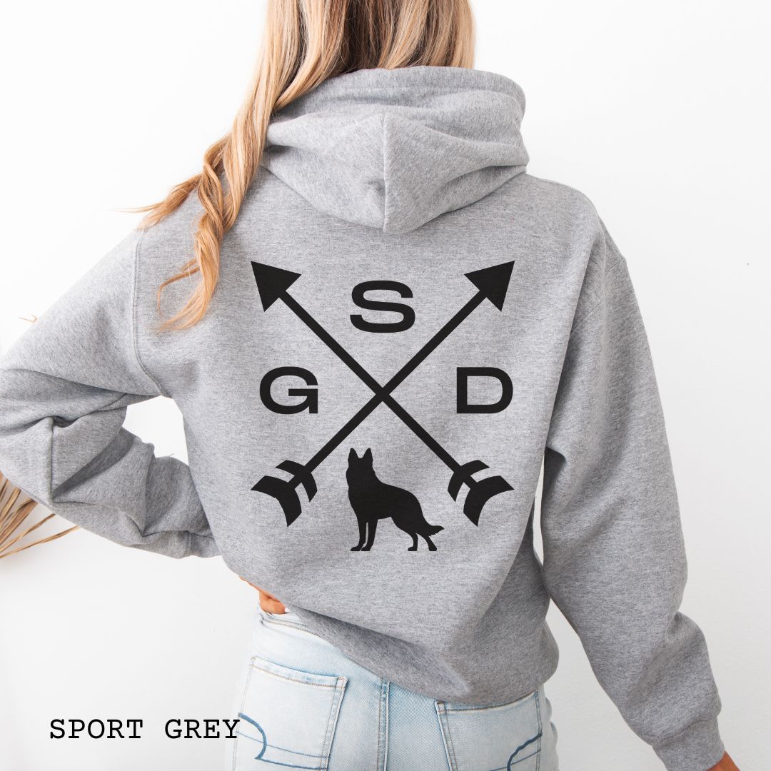 Back view of a grey unisex hoodie with a crossed arrows design with 'GSD' text and a German Shepherd silhouette, worn by a person.