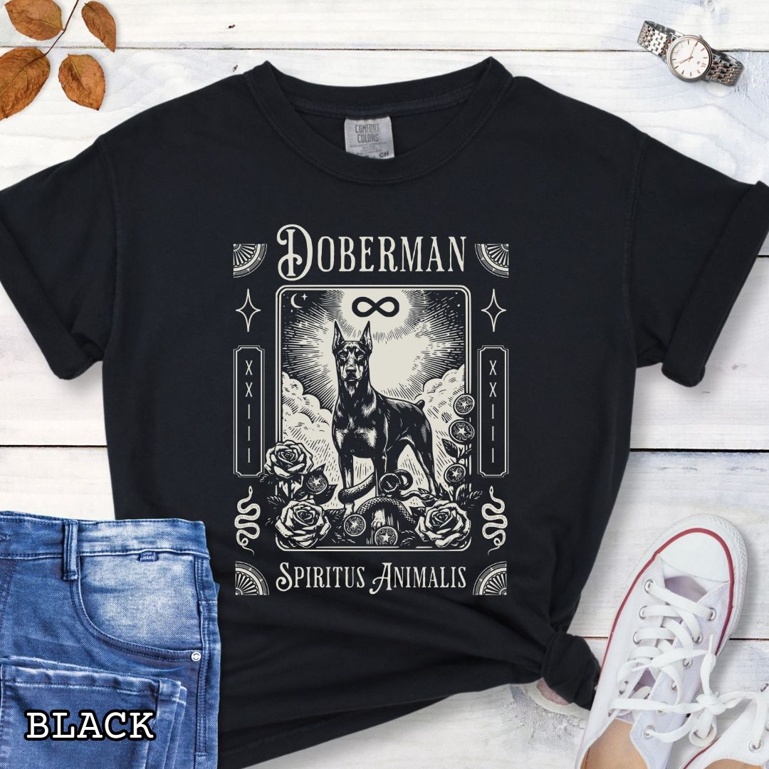 Black Comfort Colors t-shirt featuring a Doberman Pinscher tarot card design with Gothic roses and mystical symbols, perfect for Goth dog lovers and dark aesthetic Doberman fans.